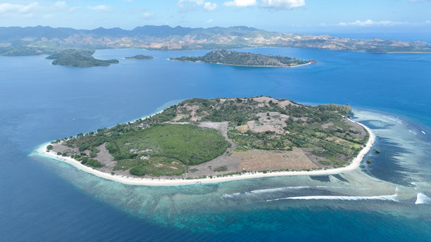 这张吉利拉亚岛的航拍照片捕捉了岛屿独特的海岸线、色彩斑斓的珊瑚礁以及延伸至远处山丘的壮丽蓝海。图片下载