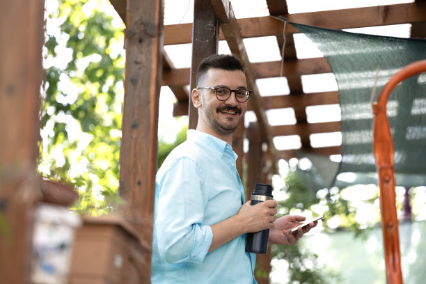 这张照片展示了一名男子在公寓阳台上享受宁静时光。图片下载