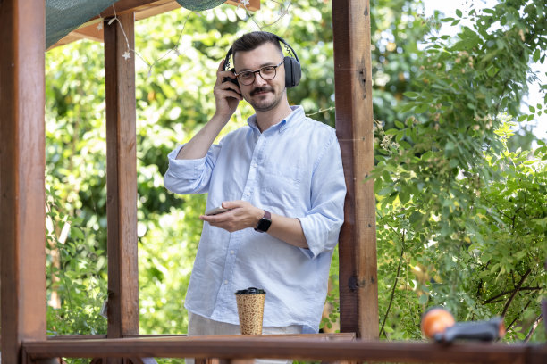 这张照片展示了一名男子在公寓阳台上享受宁静时光。图片下载