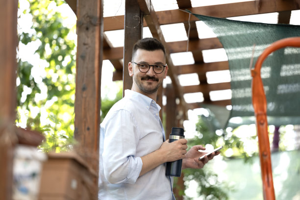 这张照片展示了一名男子在公寓阳台上享受宁静的时光。图片下载