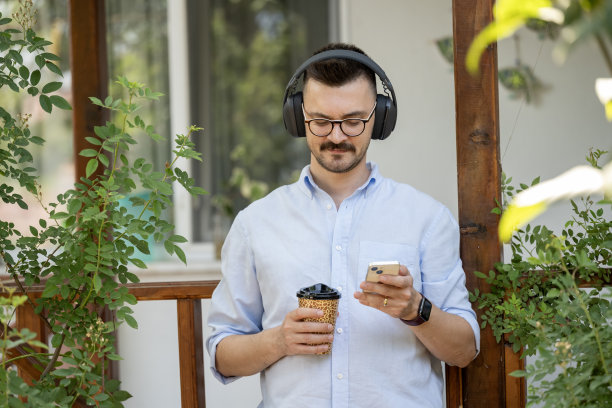 这张照片展示了一名男子在公寓阳台上享受宁静时光。图片下载
