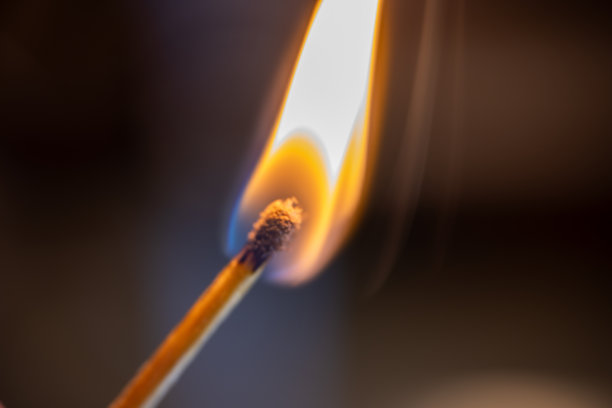 一张宏观照片，捕捉到燃烧火柴的强烈火焰。图片下载