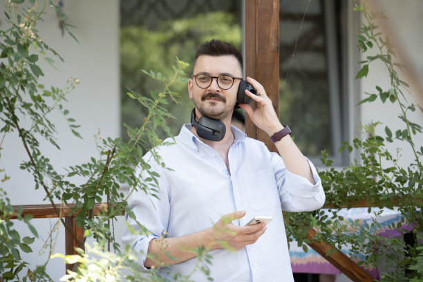 这张照片展示了一名男子在公寓阳台上享受宁静时光。图片下载