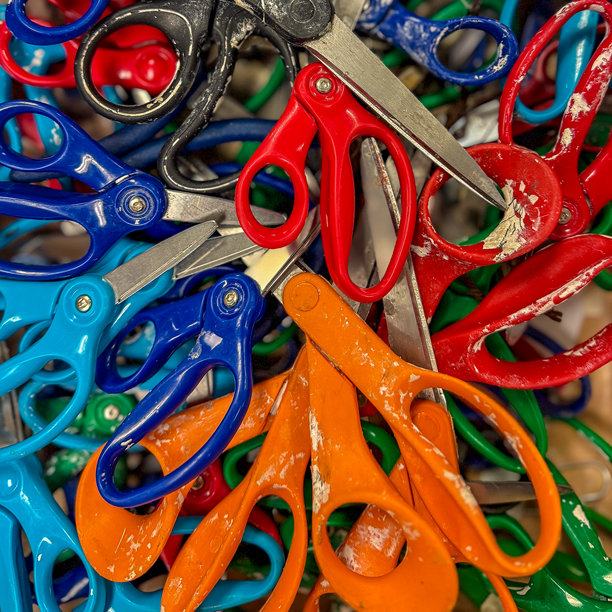 多种塑料和不锈钢艺术与手工剪刀随机排列在盒子中的彩色照片。图片下载