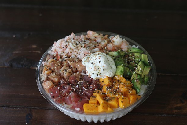 这张图片展示了一碗色彩丰富的波克碗，里面装满了新鲜的海鲜，包括虾和金枪鱼，配有米饭和各种调料，增添了风味和口感。图片下载