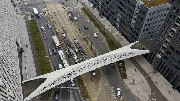 比利时安特卫普的公园桥鸟瞰图，现代行人桥连接城市区域，周围是现代建筑和城市街道，城市基础设施和交通概念的照片内容。图片下载