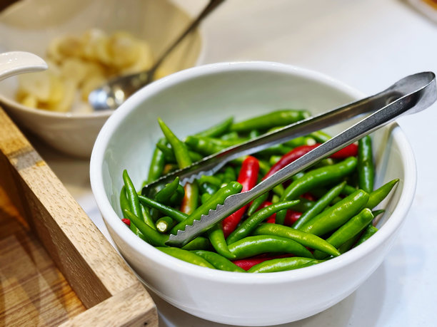 白碗中的辣椒，桌上有勺子和叉子，库存照片图片下载