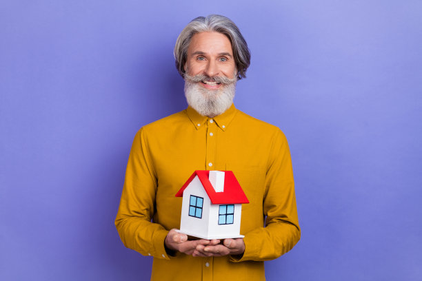 快乐的成熟男性在紫色背景下搬到新居的照片图片下载