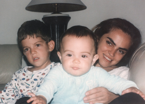 1980年代拍摄的照片：一位西班牙裔年轻母亲与她的儿子们摆姿势看向镜头图片下载