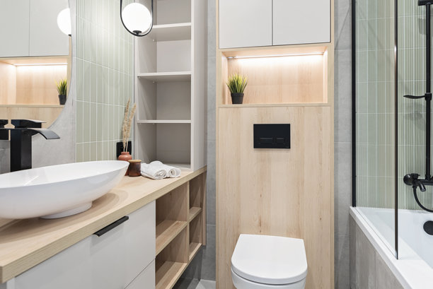 家居室内，陶瓷浴室洗手池放在橱柜上，配有黑色水龙头和带玻璃的淋浴间，墙上有镜子和马桶。室内装饰。图片下载