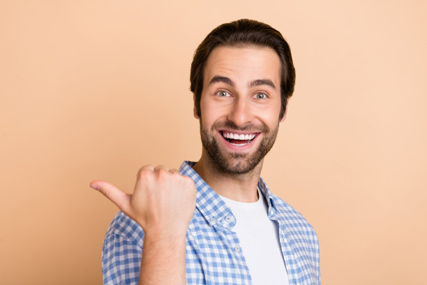 穿着蓝色衬衫的欢呼男士个人资料照片，背景为米色，空白空间。图片下载