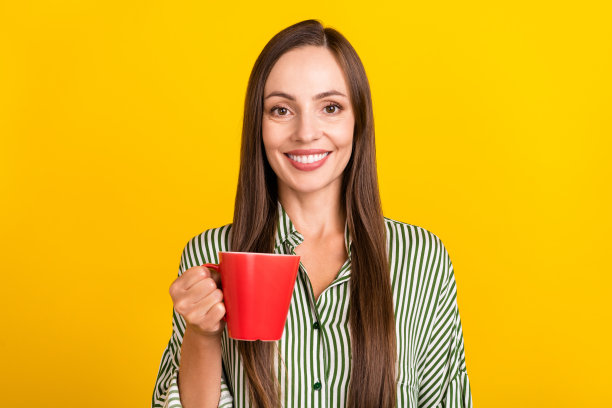 年轻快乐的漂亮女士在黄色背景下喝美式拿铁咖啡的照片图片下载