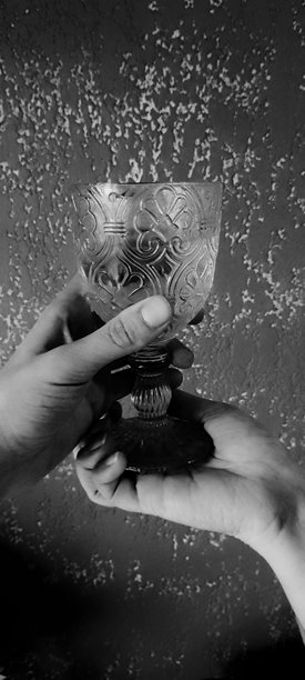 黑白照片中，两只手握着一杯卡沙萨酒。图片下载