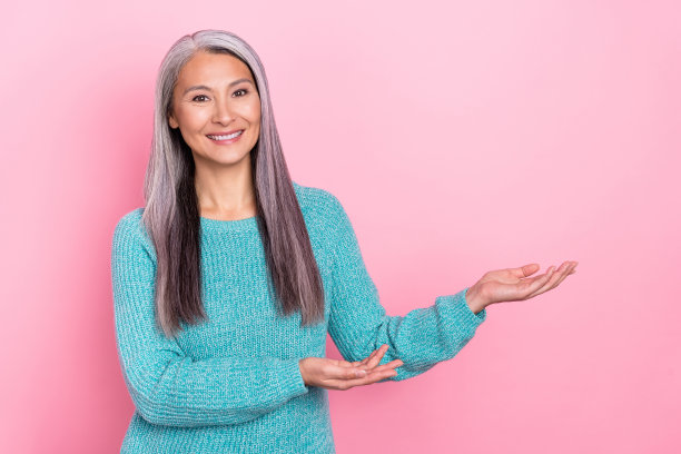 快乐的祖母在粉色背景上宣传产品并推荐替代产品的照片图片下载