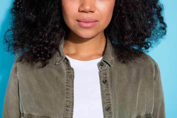 年轻非洲女性在蓝色背景下进行唇部面部护理的裁剪照片图片下载