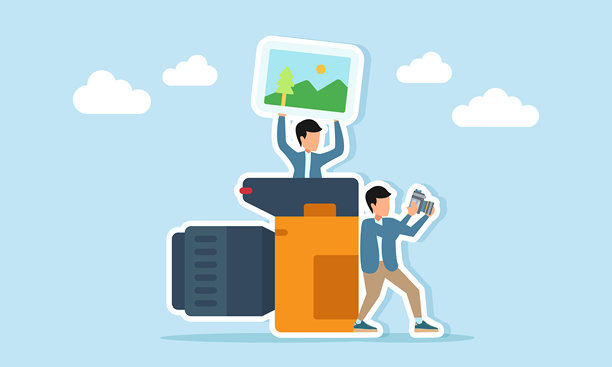 摄影师正在进行拍摄，另一人从相机后面出现，举起一本照片集，展示专业拍摄的插图。图片下载