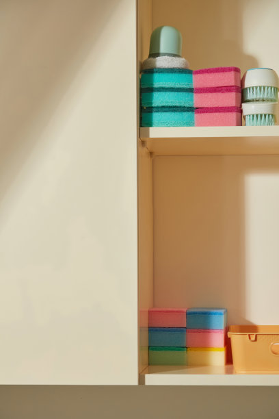 一个架子上堆放着布料和一个喷雾瓶。照片展示了一个干净、整洁的空间，准备进行家庭清洁工作。图片下载