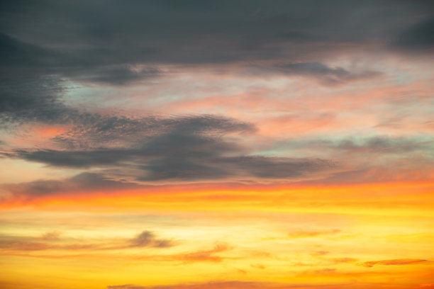 美丽的日落景观，奢华柔和的渐变橙金色云彩和阳光映照在蓝色戏剧性的天空上，完美适合作为背景，早晨、傍晚、黄昏，气候变化，横向日落照片图片下载