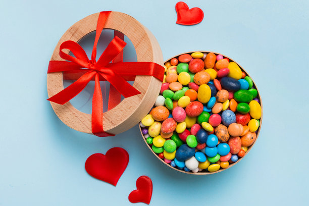 情人节构图：甜蜜的糖果，带有蝴蝶结的礼品盒和红色毛毡心，照片模板，背景。俯视图，留白空间。图片下载
