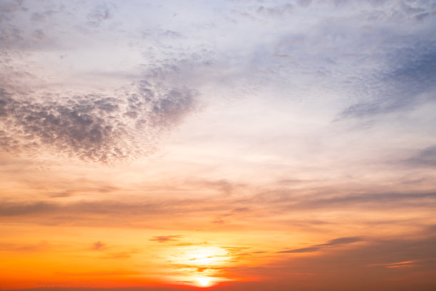 美丽的日落景观，奢华柔和的渐变橙金色云朵和阳光映照在蓝色戏剧性的天空上，完美适合作为背景，早晨、傍晚、黄昏，气候变化，横向日落照片图片下载