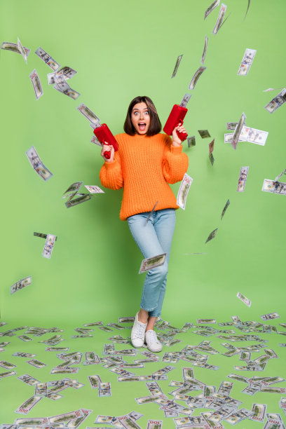 惊讶的女士穿着时尚的毛衣，手持手枪，拍摄垂直照片，背景为绿色，似乎在进行银行存款。图片下载