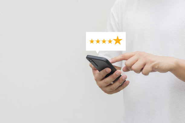 顾客男性手部特写，检查黄金五颗星评级反馈图标，并按下最佳等级以给服务评分，体现商业概念。图片下载