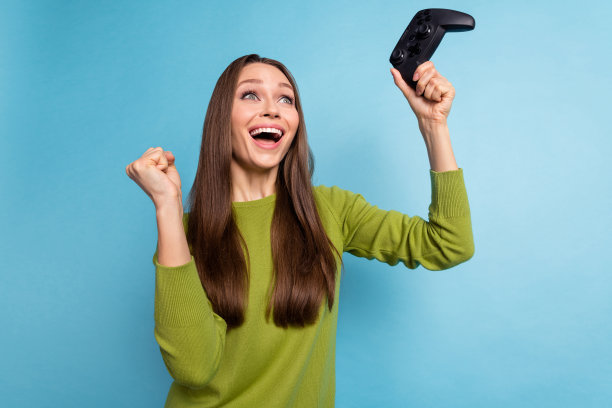 年轻快乐女孩的侧面照片，庆祝在蓝色背景下赢得比赛的胜利。图片下载