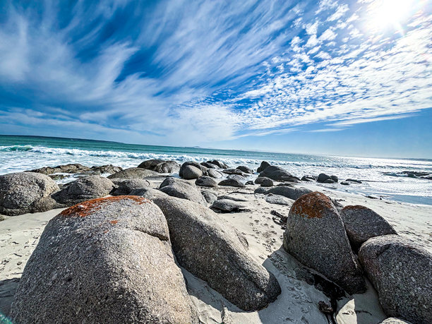 戏剧性的蓝天照片和沙滩上大石头的风景照片。南非的退潮海滩。图片下载