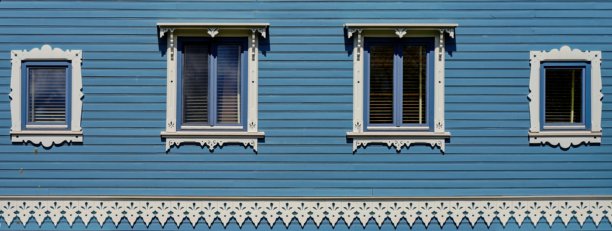蓝色木屋配有白色窗户。传统建筑风格，带有木质花纹。全景照片。图片下载