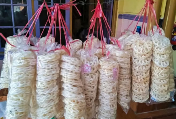 一排悬挂在绳子上的印尼零食包装袋，称为饼干。图片下载