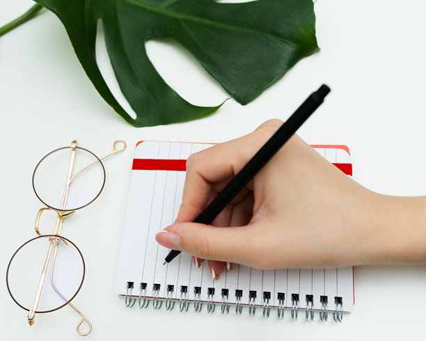 女性手部特写在计划本上做笔记。女性用笔在日记中写下信息、提醒和日程安排。手写。高质量照片。图片下载