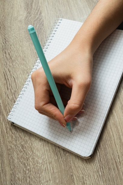 女性手部特写在计划本上做笔记。女性用笔在日记中写下信息、提醒和日程安排。手写。高质量照片。图片下载
