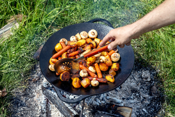 铁铸锅上烤制的香菇、香肠和土豆。夏季自然中的野餐。食物的横向照片。图片下载