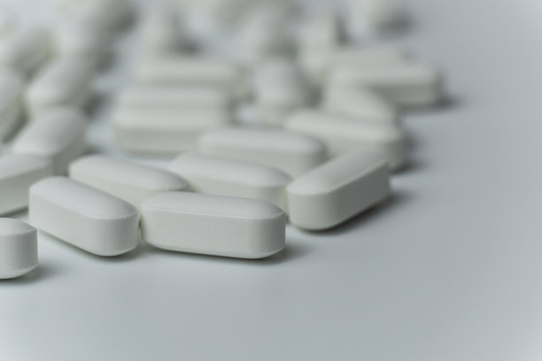 一组白色药片在浅灰色背景上的特写宏观照片图片下载