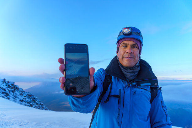 登山者在伊萨查瓦特山上用智能手机展示波波卡特佩特火山的照片图片下载