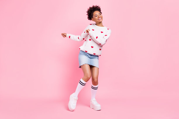 穿着白色毛衣的可爱非洲女士在蓝色背景下跳舞微笑的照片图片下载