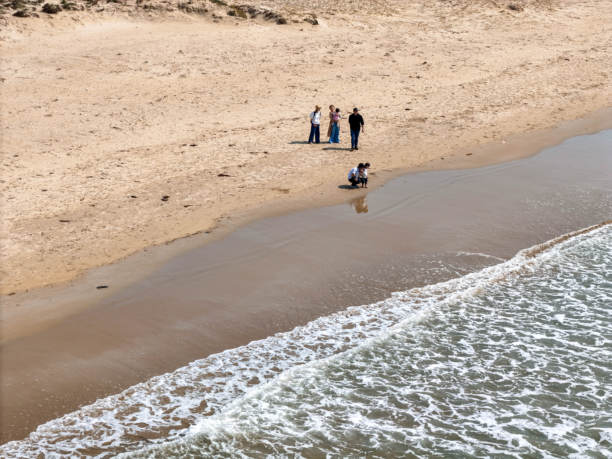 福冈海滩的航拍照片，面向日本海，展示了一家日本家庭，包含一个6个月大的婴儿、一个1岁的小孩、一个3岁的小女孩和30多岁的父母。家庭摄影。图片下载