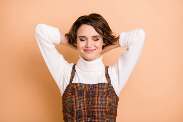 高角度俯视照片，年轻可爱美丽的女孩在柔和色彩背景下微笑，享受闲暇时光。图片下载