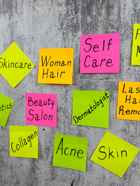 带有美容术语的彩色便签的竖版照片。时尚行业商业组成部分的描述。保持健康身体的复杂性，包括皮肤和头发护理。图片下载