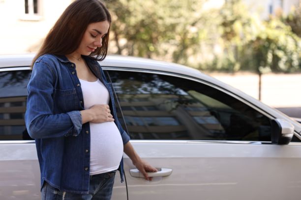 美丽的孕妇在户外打开车门图片下载