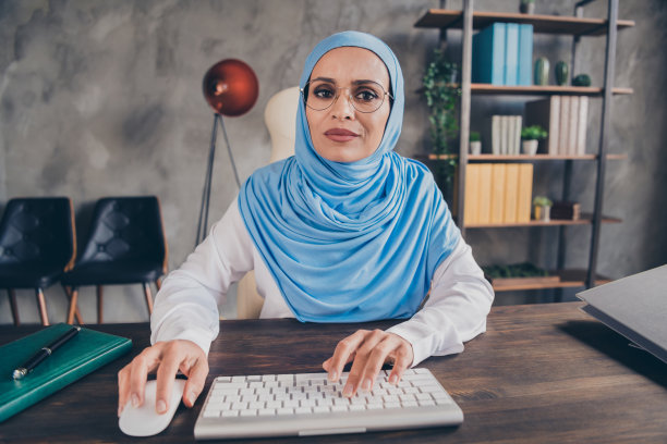 年轻阿拉伯女商人自由职业者程序员经济学家在室内专注地聊天和打邮件的照片图片下载