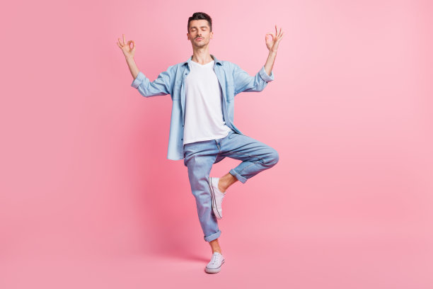 全身照片，平静安详的男子在粉色背景上做出“OM”手势，享受周末休息。图片下载