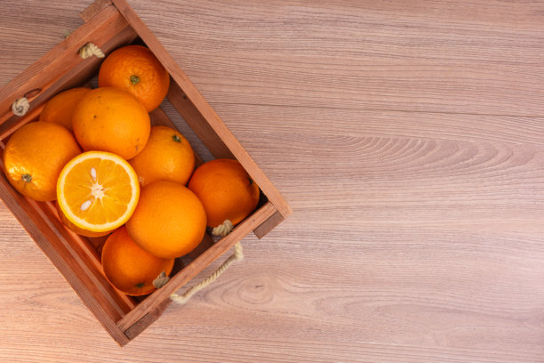 高分辨率相机和堆叠技术拍摄的真实橙子篮子照片，背景为棕色木材。图片下载