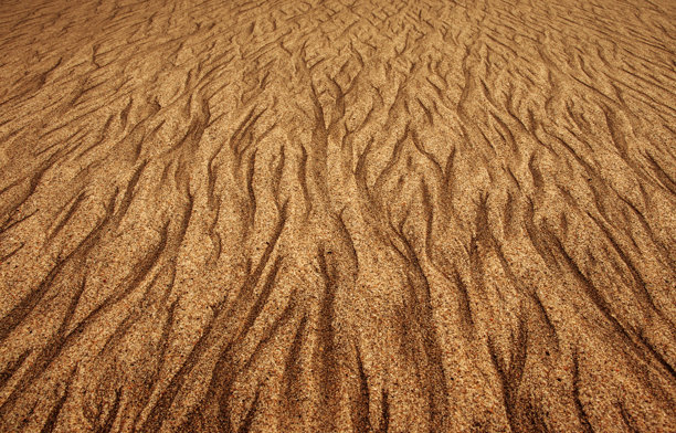 金棕色调的海滩沙子与石头的照片，抽象的精美艺术图案，梦幻般的背景，日落光线下的自然风景图片下载