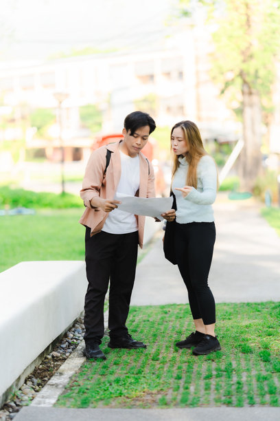 亚洲男女游客情侣在街上行走，使用地图和智能手机导航城市街道，探索旅游期间的城市区域。旅行科技 竖版图片图片下载