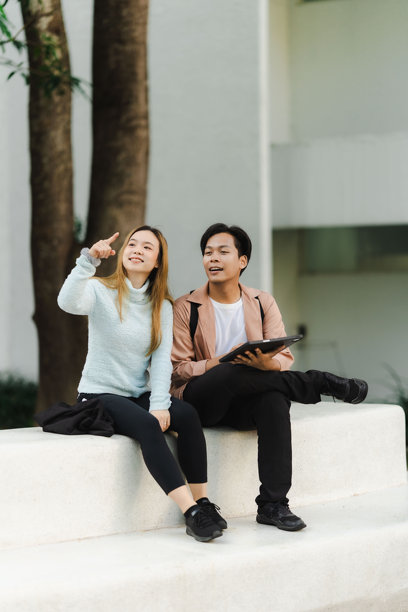 亚洲男女游客情侣在街上行走，使用地图和智能手机导航城市街道，探索旅游期间的城市区域。旅行科技 竖版图片图片下载