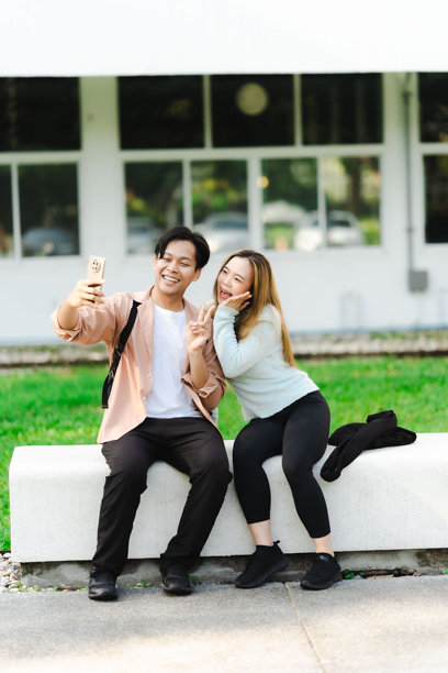 亚洲男女游客情侣在街上行走，使用地图和智能手机导航城市街道，探索旅游期间的城市区域。旅行科技 竖版图片图片下载