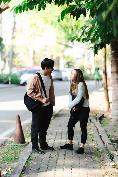 亚洲男女游客情侣在街上行走，使用地图和智能手机导航城市街道，探索旅游期间的城市区域。旅行科技 竖版图片图片下载