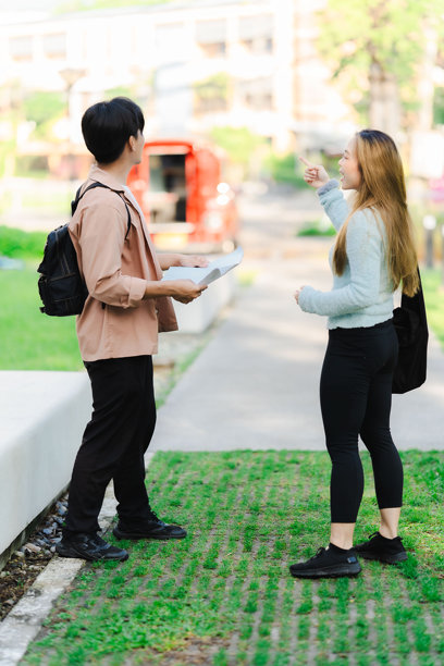 亚洲男女游客情侣在街上行走，使用地图和智能手机导航城市街道，探索旅游期间的城市区域。旅行科技 竖版图片图片下载