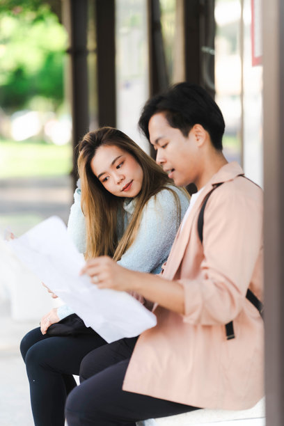 亚洲男女游客情侣在街上行走，使用地图和智能手机导航城市街道，探索旅游期间的城市区域。旅行科技 竖版图片图片下载